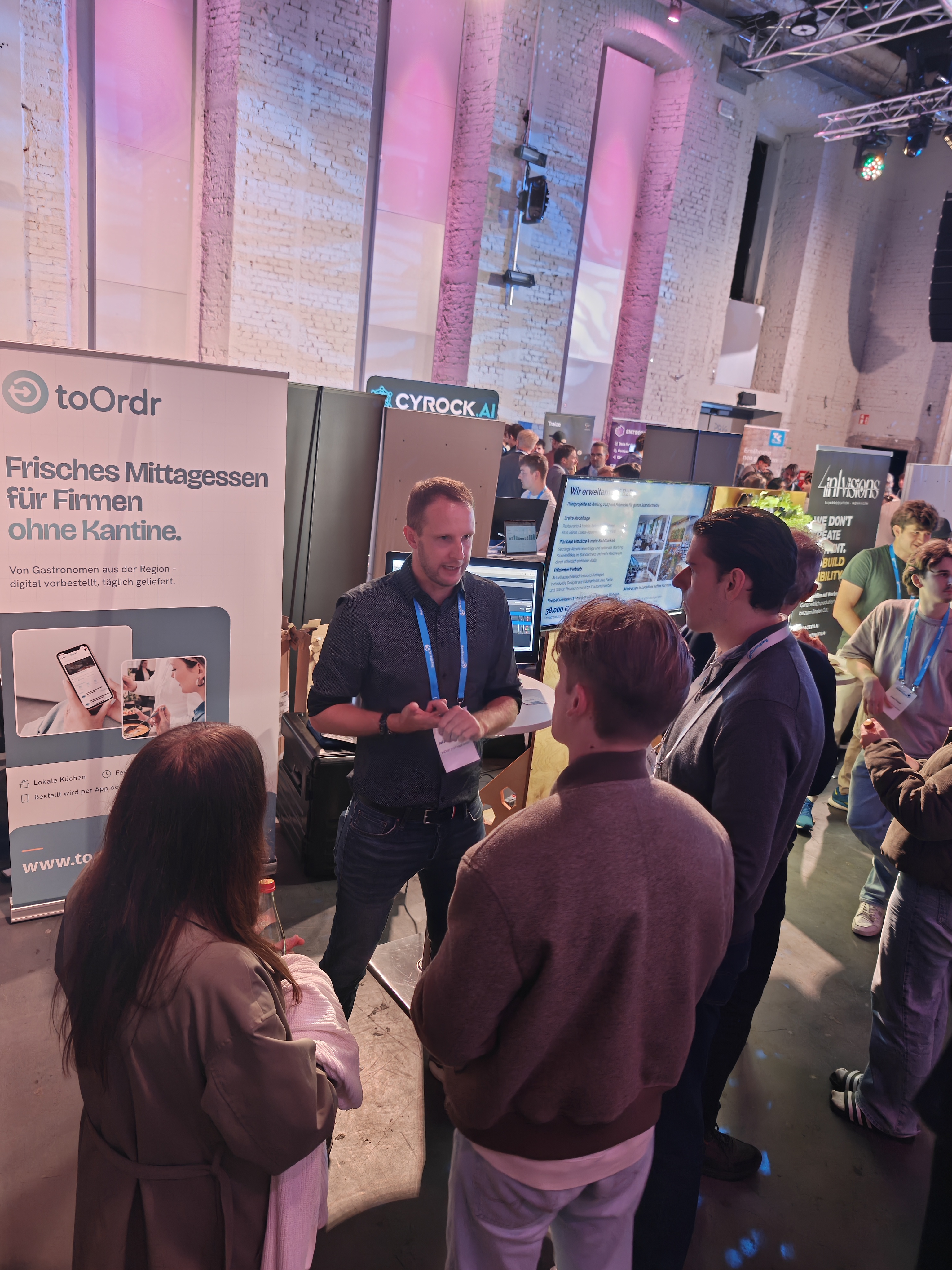 SchülerInnen werden auf der Demo-Night an einem Stand über ein Startup informiert.