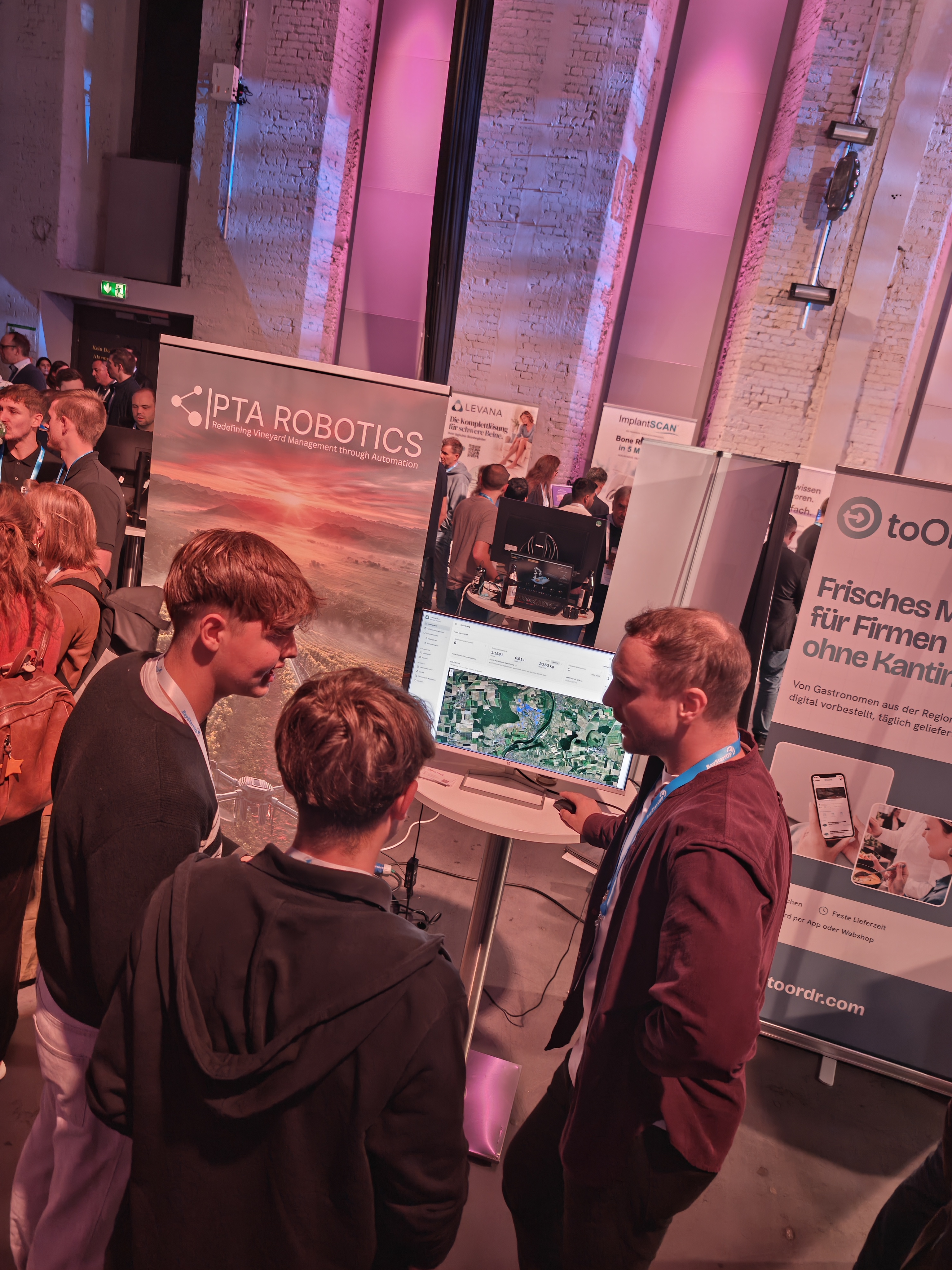 SchülerInnen werden auf der Demo-Night an einem Stand über ein Startup informiert.